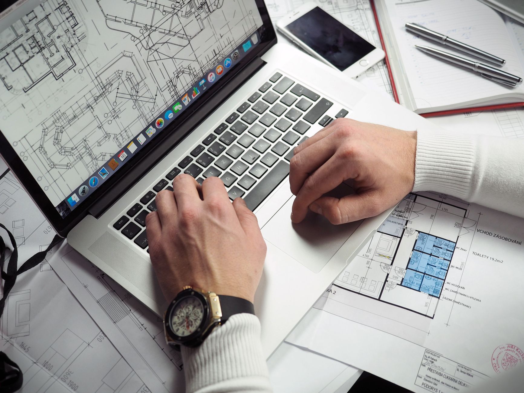Architekt analizuje na laptopie plany domu energooszczędnego i normy
