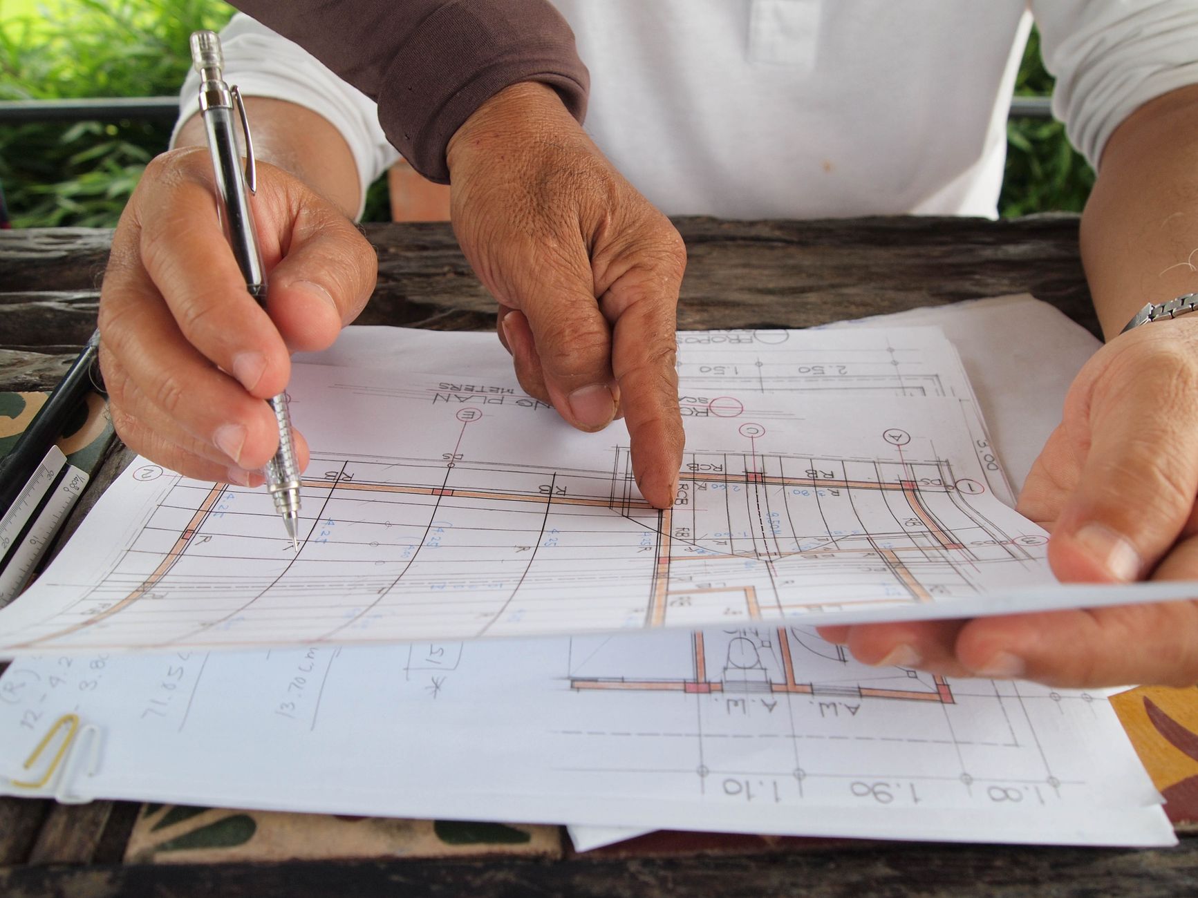 Dwóch architektów omawia plany domu energooszczędnego przy biurku