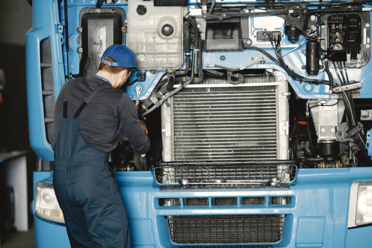 Mechanik w warsztacie pracujący przy silniku ciężarówki